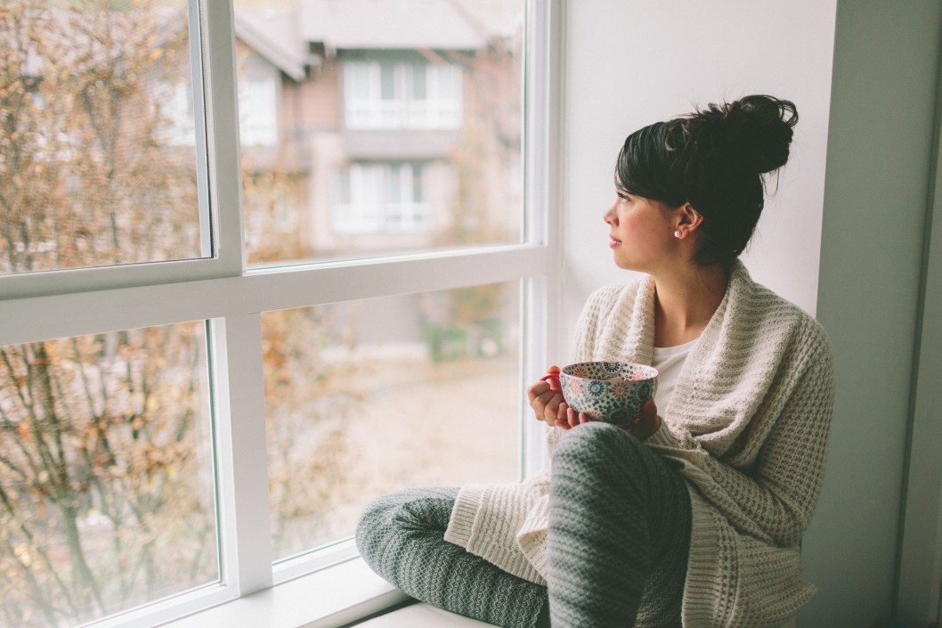 a-young-woman-looking-out-from-the-window-drinking-tea_t20_XzWgWz.jpg